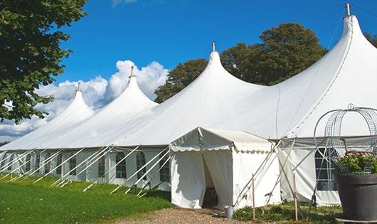 tall green portable restrooms assembled at a music festival, contributing to an organized and sanitary environment for guests in Malden